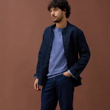 Dunkelblaues Jeanshemd und hellblaues Shirt kombiniert mit einer dunkelblauen Hose.
