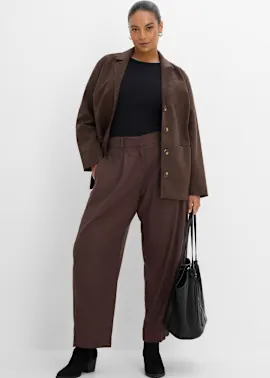 Brauner Blazer, schwarzes Top, weite braune Hose, schwarze Stiefel und Tasche.
