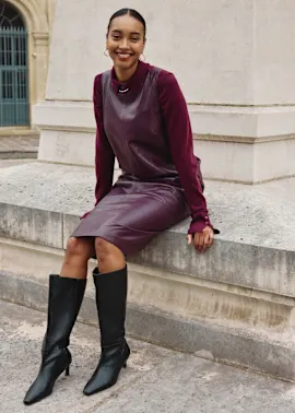 Burgunderrotes Kleid mit langen Ärmeln, kombiniert mit schwarzen Lederstiefeln.