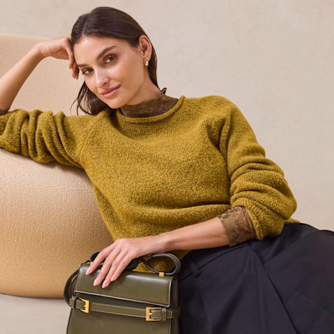 Warmer senfgelber Pullover trifft auf eleganten schwarzen Rock.