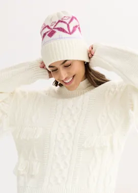 Winterlicher Look: Gemütliche Strickmütze und cremefarbener Zopfmusterpullover mit Fransen.