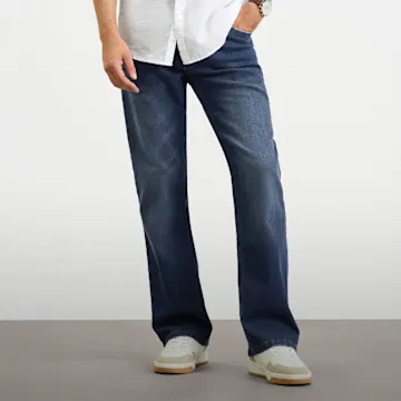 Lässige Regular-Fit Jeans und weißes Hemd, kombiniert mit modernen Sneakern.
