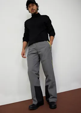 Eleganter schwarzer Rollkragenpullover kombiniert mit grauer Thermo-Hosen.