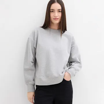 Schlichtes graues Sweatshirt mit Rundhalsausschnitt, kombiniert mit dunkler Hose.