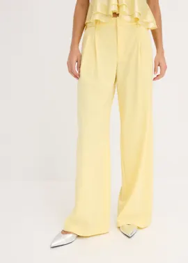 Helle gelbe Hose, passendes Oberteil und schicke spitze Silberschuhe.