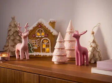 Weihnachtsdekoration: rosa Hirsche und leuchtende Bäume.