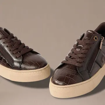 Zwei schicke braune Sneaker mit Kroko-Muster, Schnürsenkeln und seitlichen Reißverschlüssen.