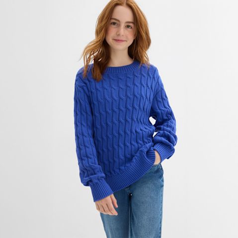 Blaues Strickmuster-Pullover mit Zopfmuster, kombiniert mit klassischer Jeans für einen lässigen Look.