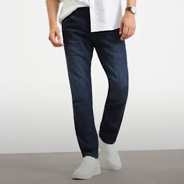 Dunkelblaue Slim-Fit Jeans, weißes Hemd und weiße Sneaker.