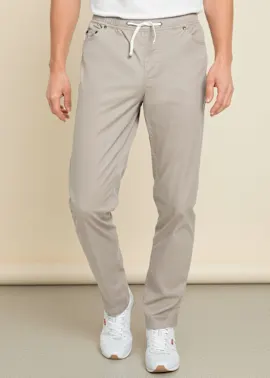Bequeme beige Hose mit Kordelzug, weißem T-Shirt und sportlichen Sneakern.