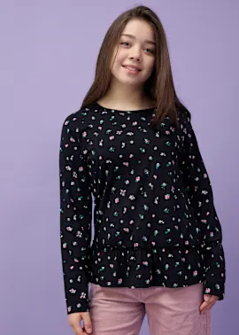 Schwarzes Oberteil mit Blumenprint, kombiniert mit einer rosafarbenen Hose.