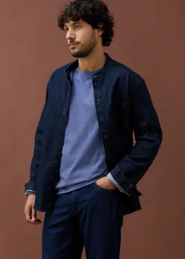 Dunkelblaues Jeanshemd und hellblaues Shirt kombiniert mit einer dunkelblauen Hose.