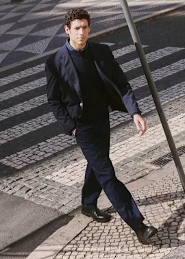 Eleganter dunkler Anzug mit schwarzem Pullover.
