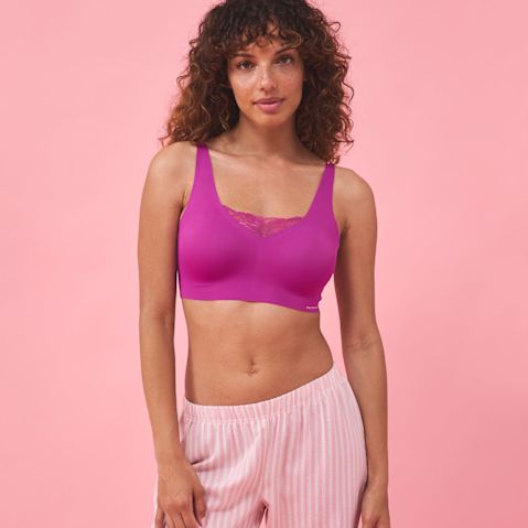 Farbenfrohe Kombination: Violettes Sport-Top trifft auf luftige, gestreifte Hose. Sommerlicher Look für aktive Tage.
