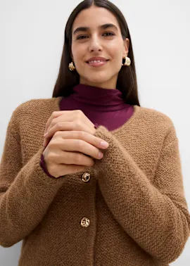 Frau trägt eine weit geschnittene Strickjacke in braun.