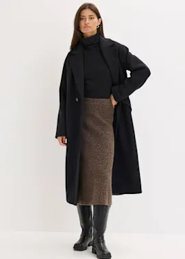 Eleganter schwarzer Mantel über Rollkragenpullover, kombiniert mit braunem Midirock und kniehohen Lederstiefeln.
