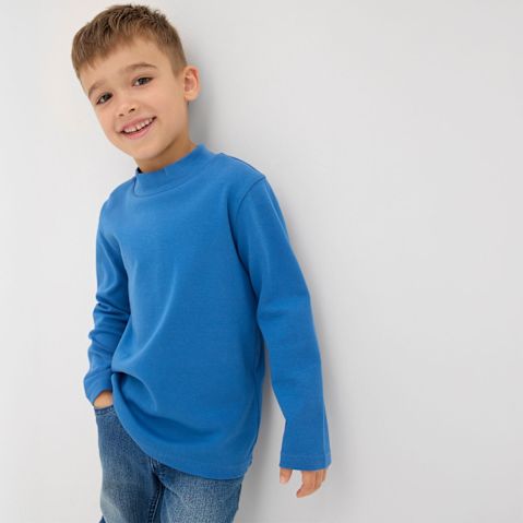 Blauer Pullover mit langen Ärmeln und eine klassische blaue Jeans.