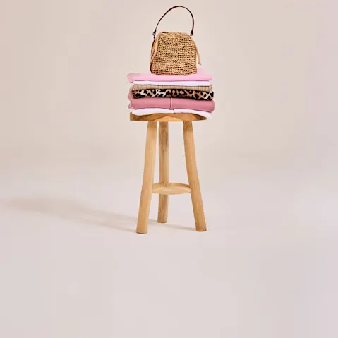 Sommerliche Strandtasche aus Stroh mit Sonnenbrille ruht auf Holzsteg am idyllischen See.