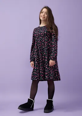 Blumenkleid mit langen Ärmeln, schwarze Strumpfhose und kuschelige Boots.