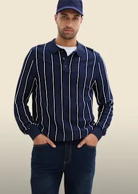 Blaue Kappe, gestreiftes Langarm-Poloshirt und dunkle Jeans bilden einen lässigen Look.