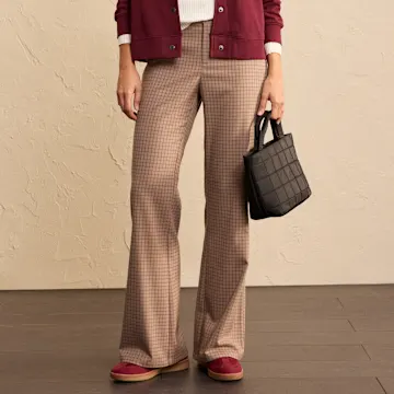 Karierte Hose und weinrote Jacke kombiniert mit bequemen Schuhen und Handtasche.