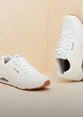 Zwei weiße Skechers-Sneaker mit brauner Sohle, sportlich und bequem.