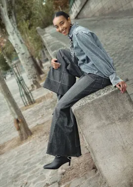 Kombination aus Jeansjacke, grauem Mantel und Jeans.