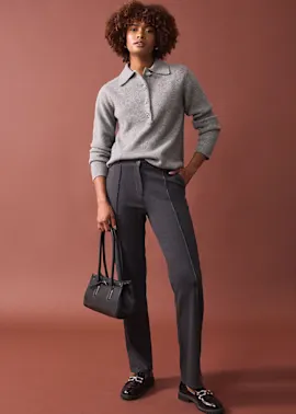 Eleganter grauer Pullover kombiniert mit schicken Anzughosen und schwarzen Loafers.
