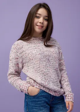 Ein gemütlicher Strickpullover in Rosa-Tönen, kombiniert mit einer blauen Jeans.