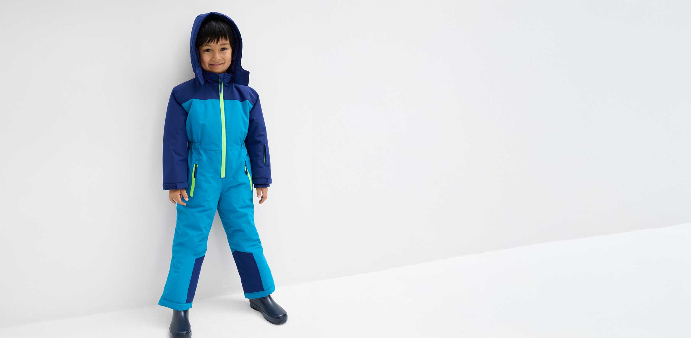 Kleiner Junge im Schneeanzug.