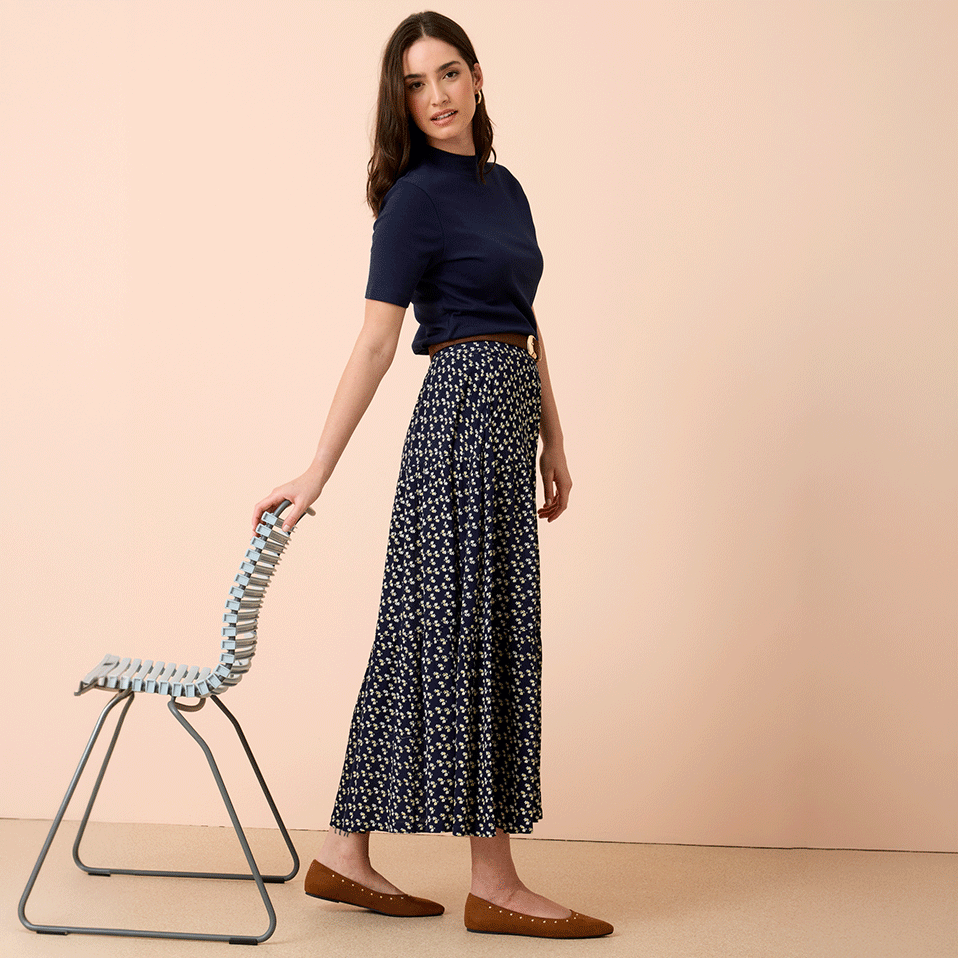 Marineblaues Oberteil trifft auf gemusterten Maxirock. 