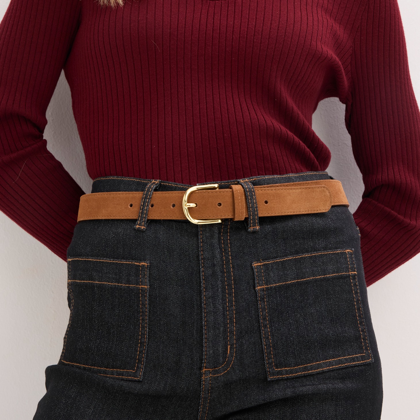 Strickpullover kombiniert mit Jeans und braunem Ledergürtel.