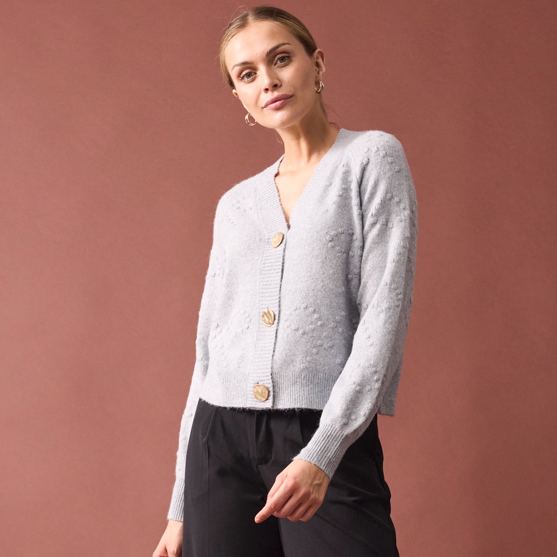 Elegante weiße Strickjacke mit großen Knöpfen.