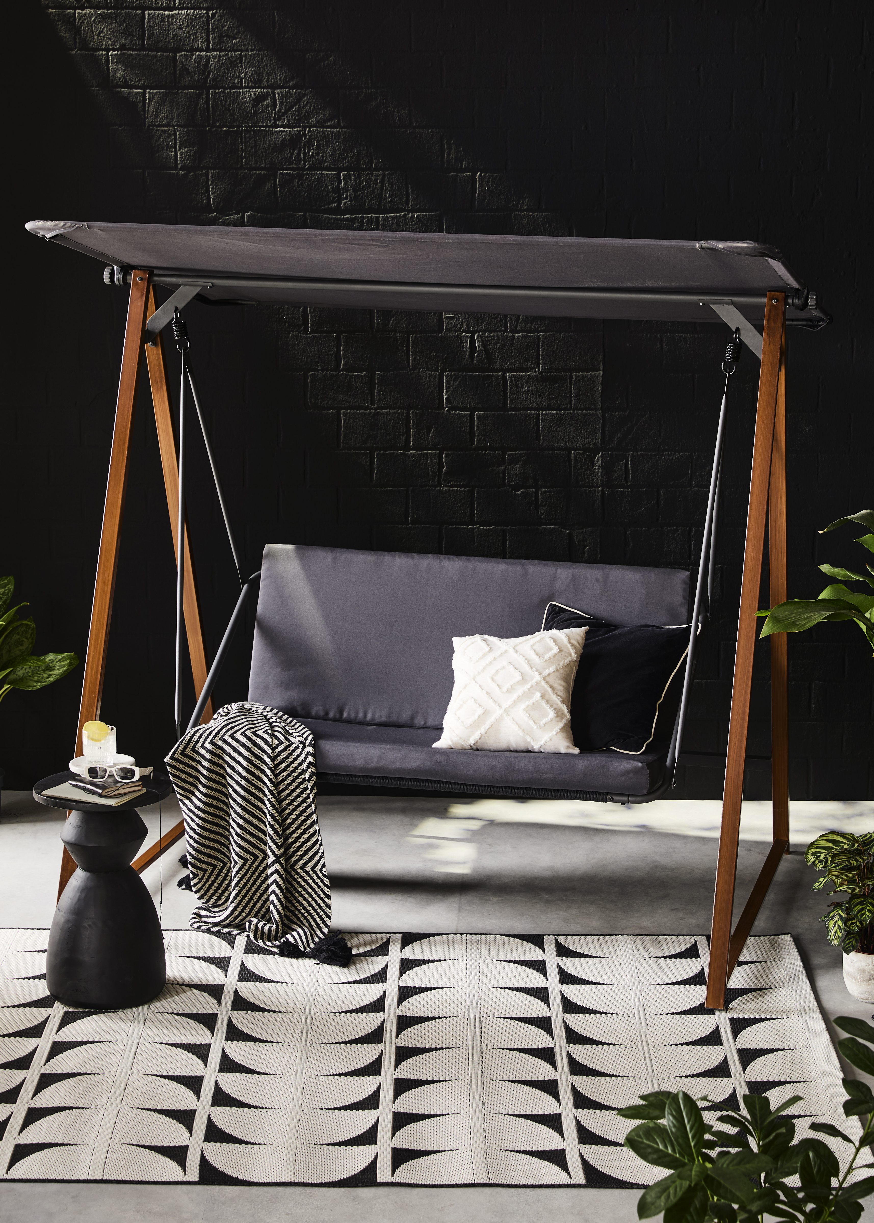 Elegante Hollywoodschaukel mit grauem Sonnendach und passenden Sitzkissen für entspannte Momente im Garten.