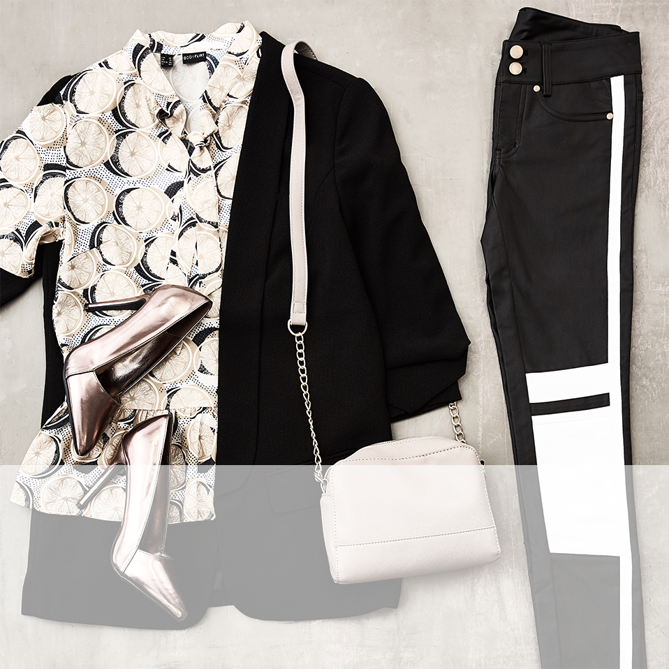 Stilvolle Kombination aus geblümter Bluse, schwarzem Blazer und modernen Jeans mit weißem Streifen.