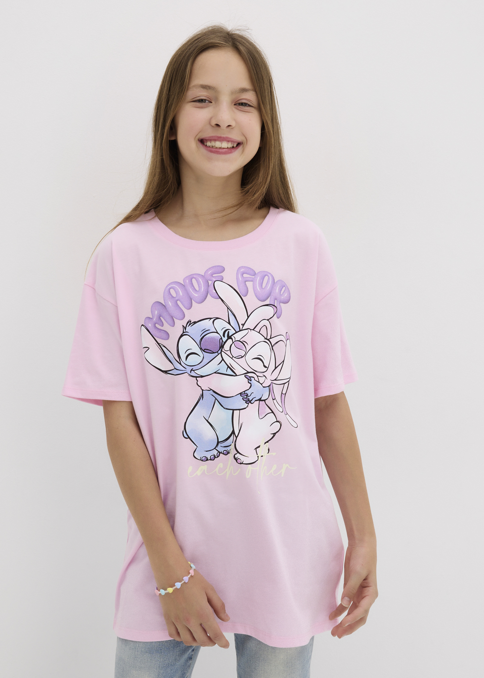 Stylishes rosa T-Shirt mit Stitch & Angel Print, kombiniert mit Jeans.