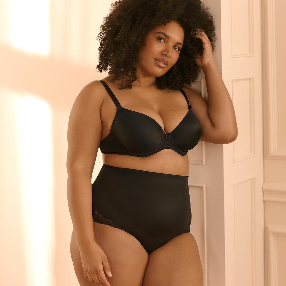 Elegante schwarze Dessous: BH mit dünnen Trägern und hochgeschnittenes Höschen für kurvige Silhouette.