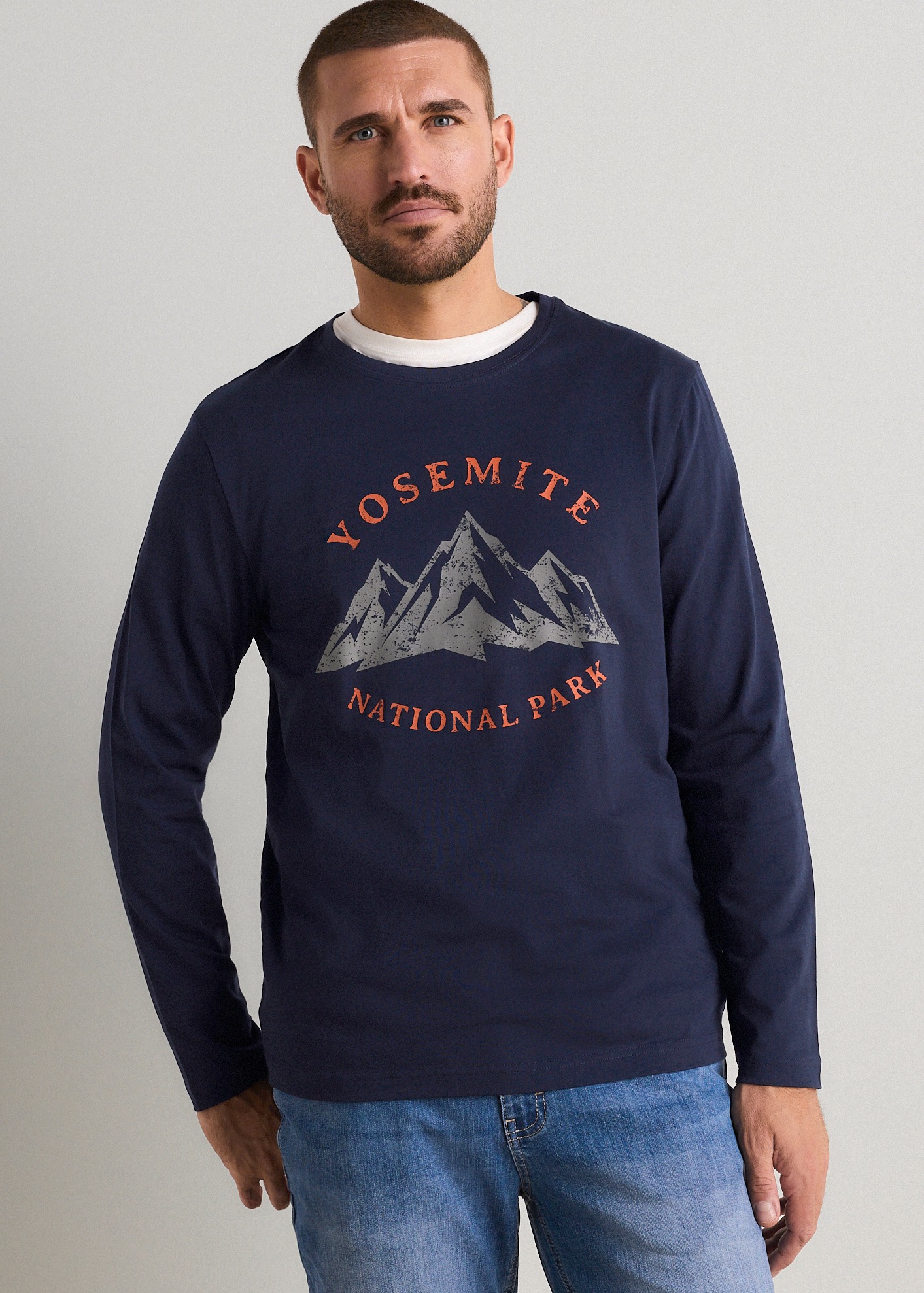Dunkelblaues Langarmshirt mit Yosemite-Print und Jeans für einen lässigen Stil.