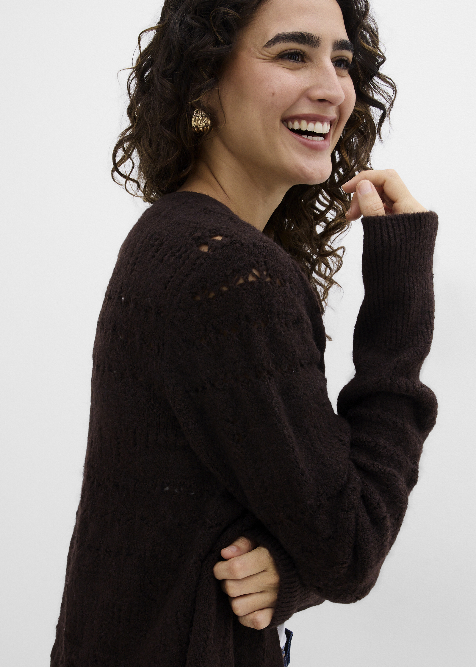 Frau trägt eine braune Strickjacke.