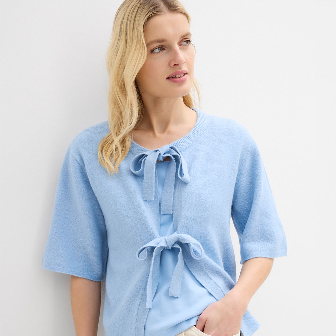 Himmelblaues Strickoberteil mit Schleifendetails.