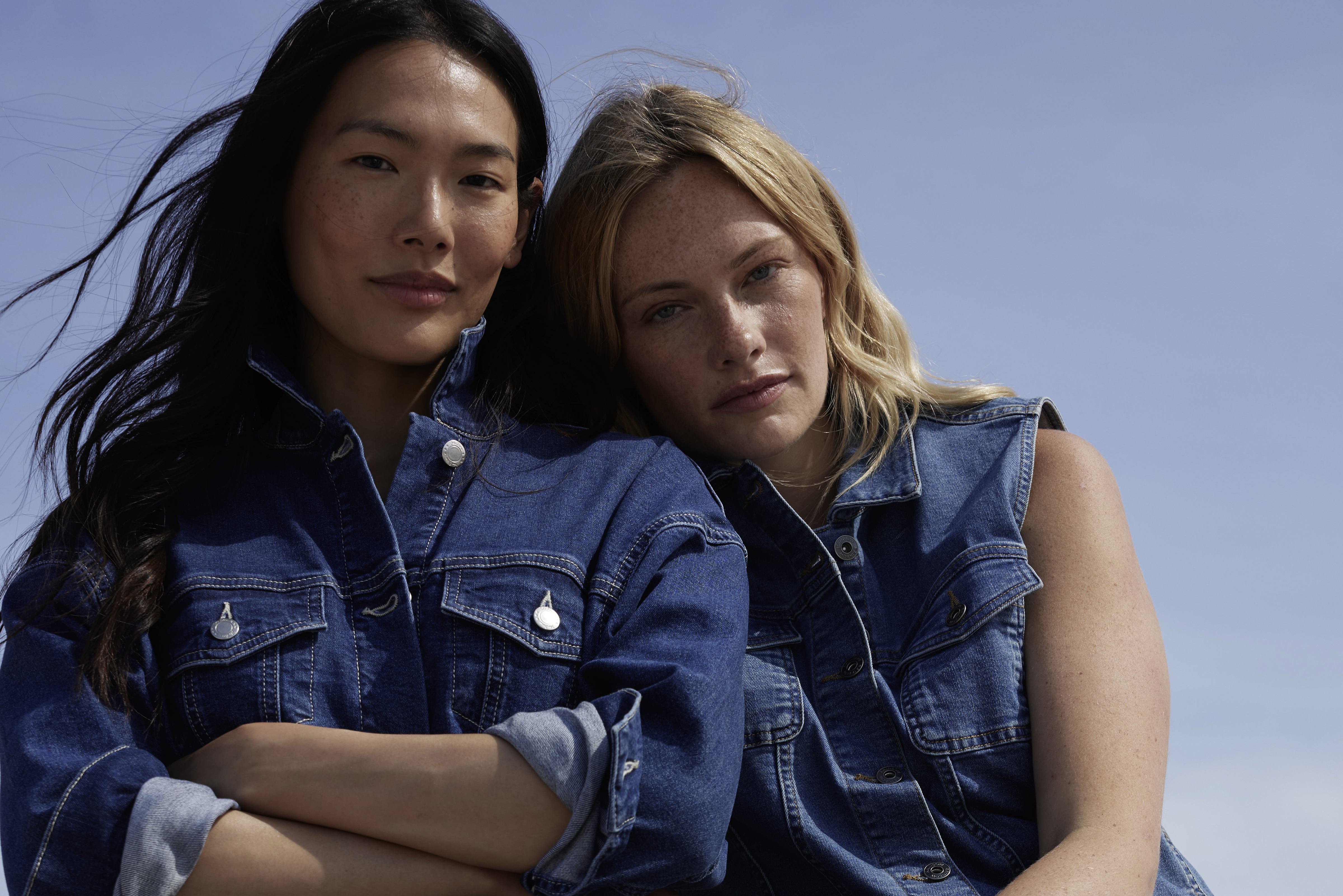 Zwei Personen in lässigem Denim: Eine in Jeansjacke, die andere in ärmelloser Jeansweste.