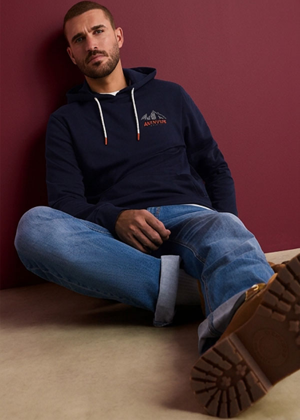 Lässiger Look mit rosa Streifenhemd, blauer Jeans und bequemen braunen Slippern.