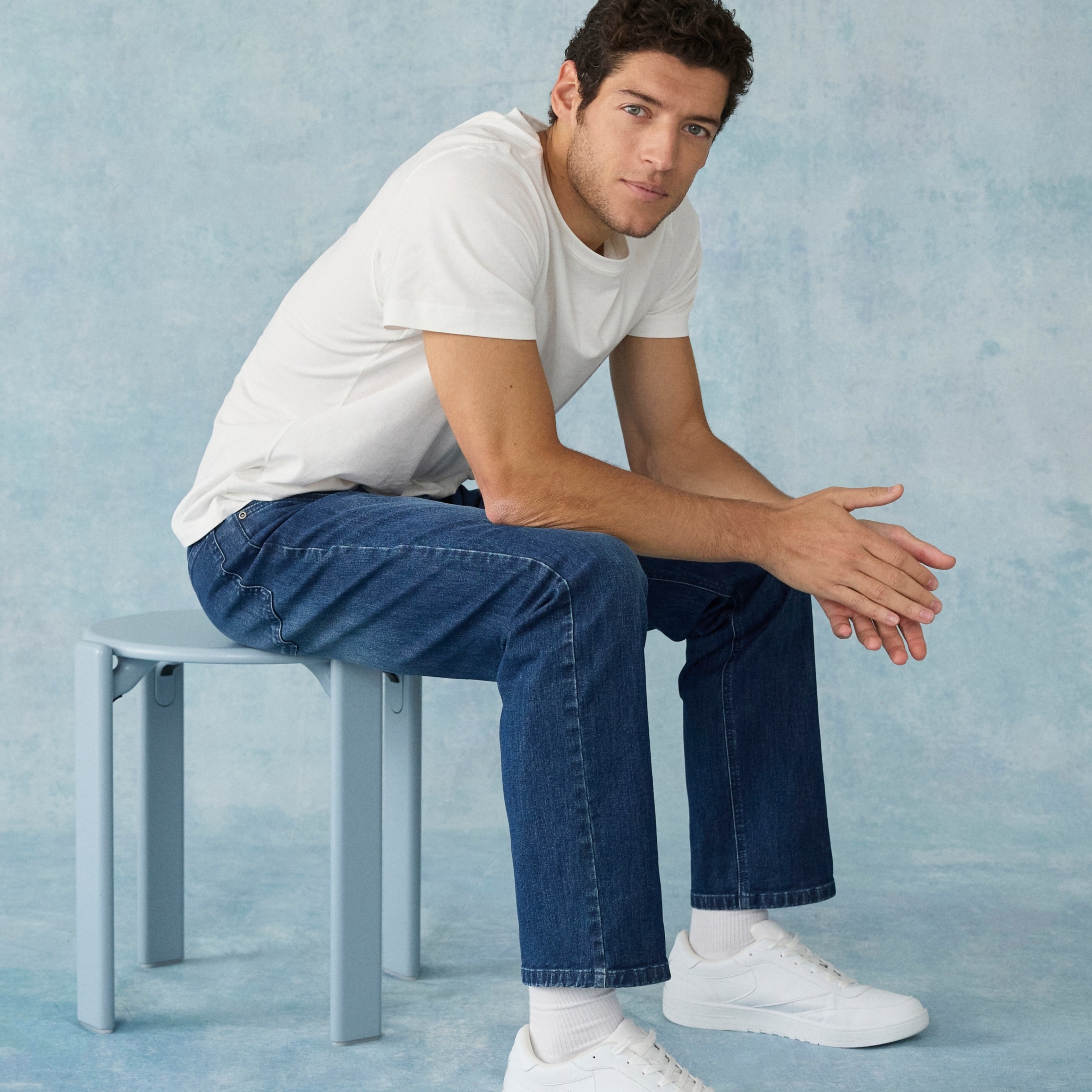 Klassischer Look: Weißes T-Shirt, blaue Jeans und weiße Sneakers. Einfach und zeitlos.