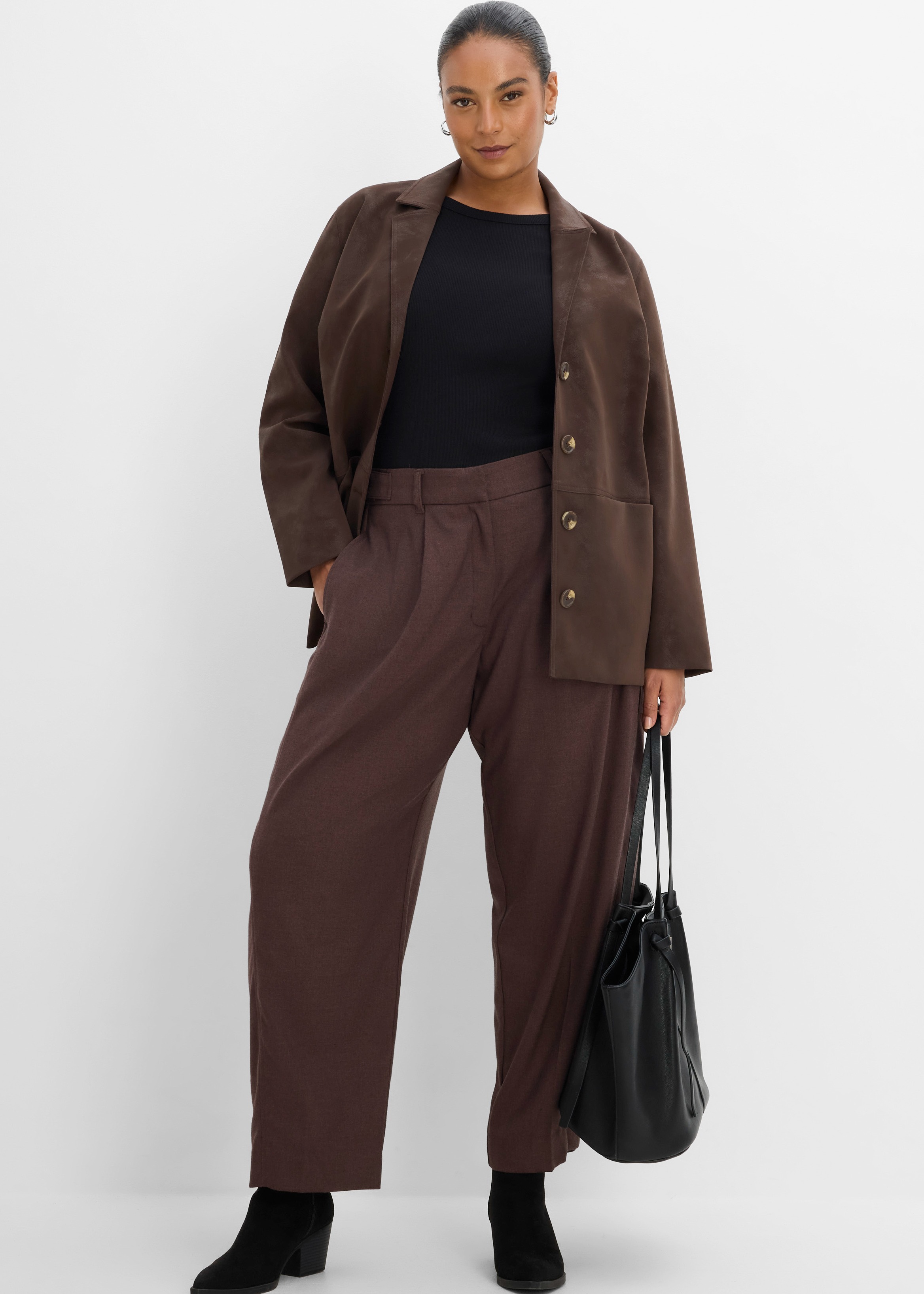 Brauner Blazer, schwarzes Top, weite braune Hose, schwarze Stiefel und Tasche.
