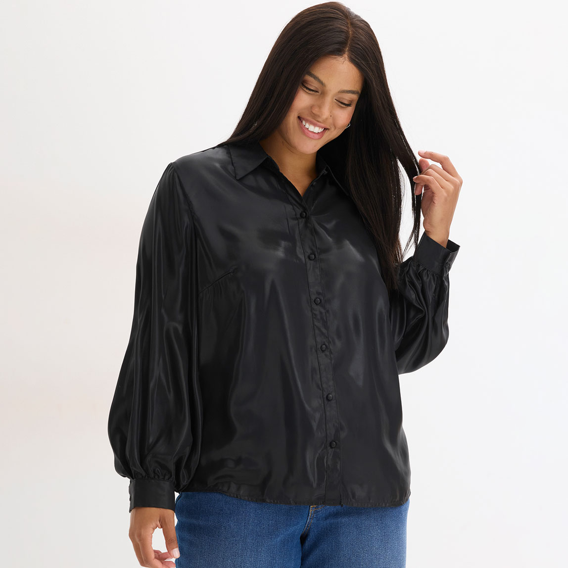 Schwarze Bluse mit Kragen und Knöpfen, kombiniert mit blauen Jeans.