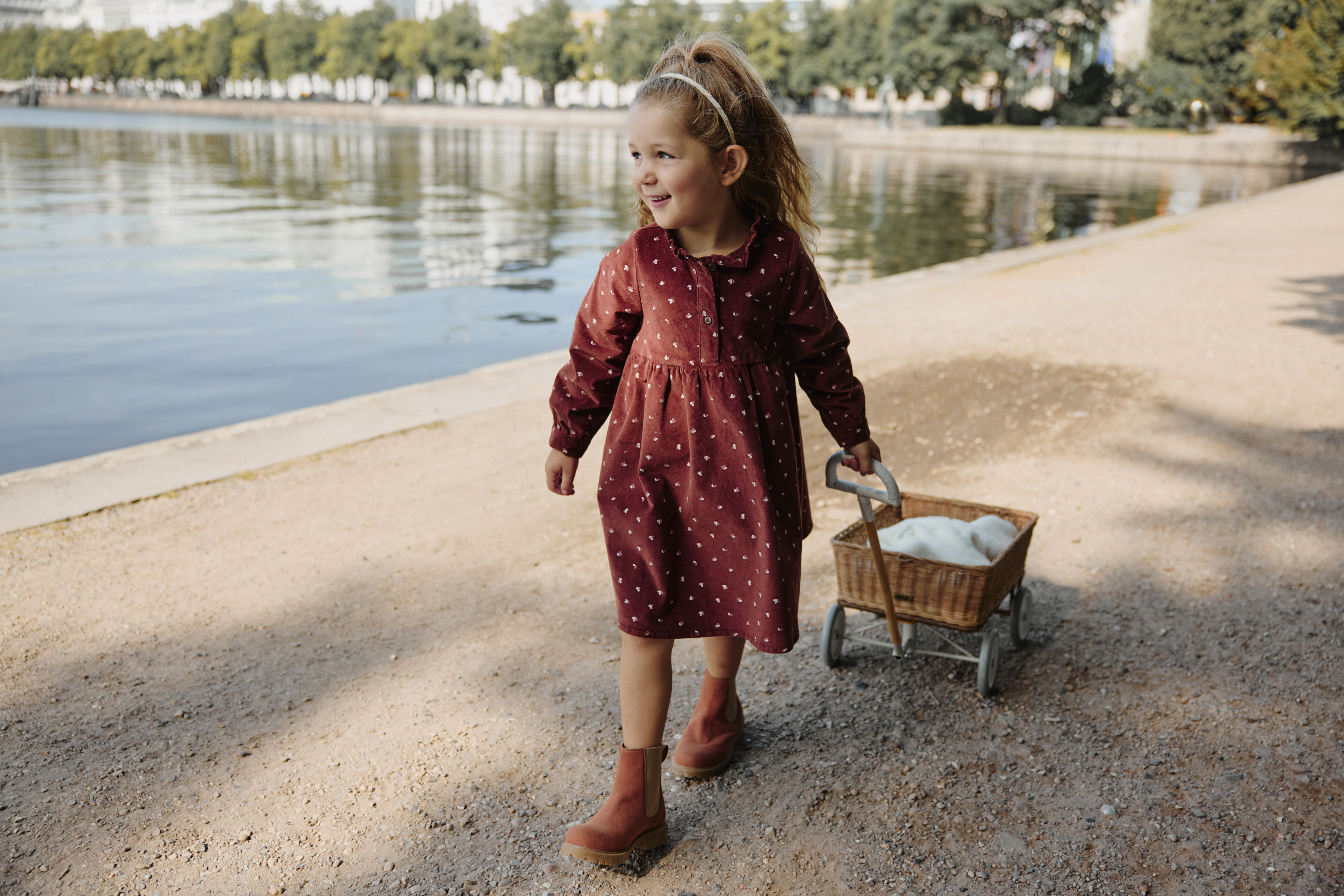 Ein rotes gepunktetes Kleid und braune Stiefel - perfekt für einen Herbstspaziergang am See.