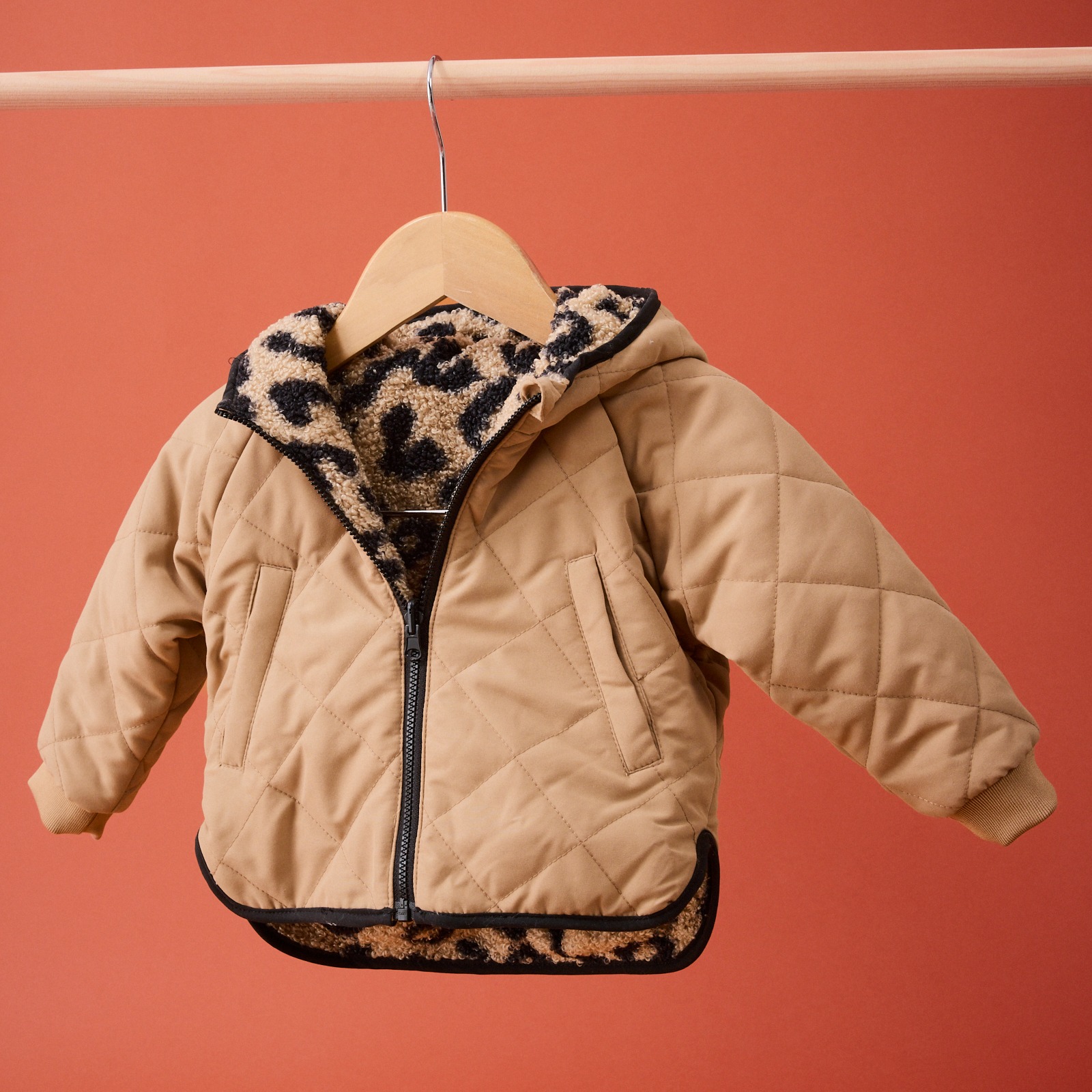 Beige Kinder-Steppjacke mit Leo-Muster als Innenfutter.