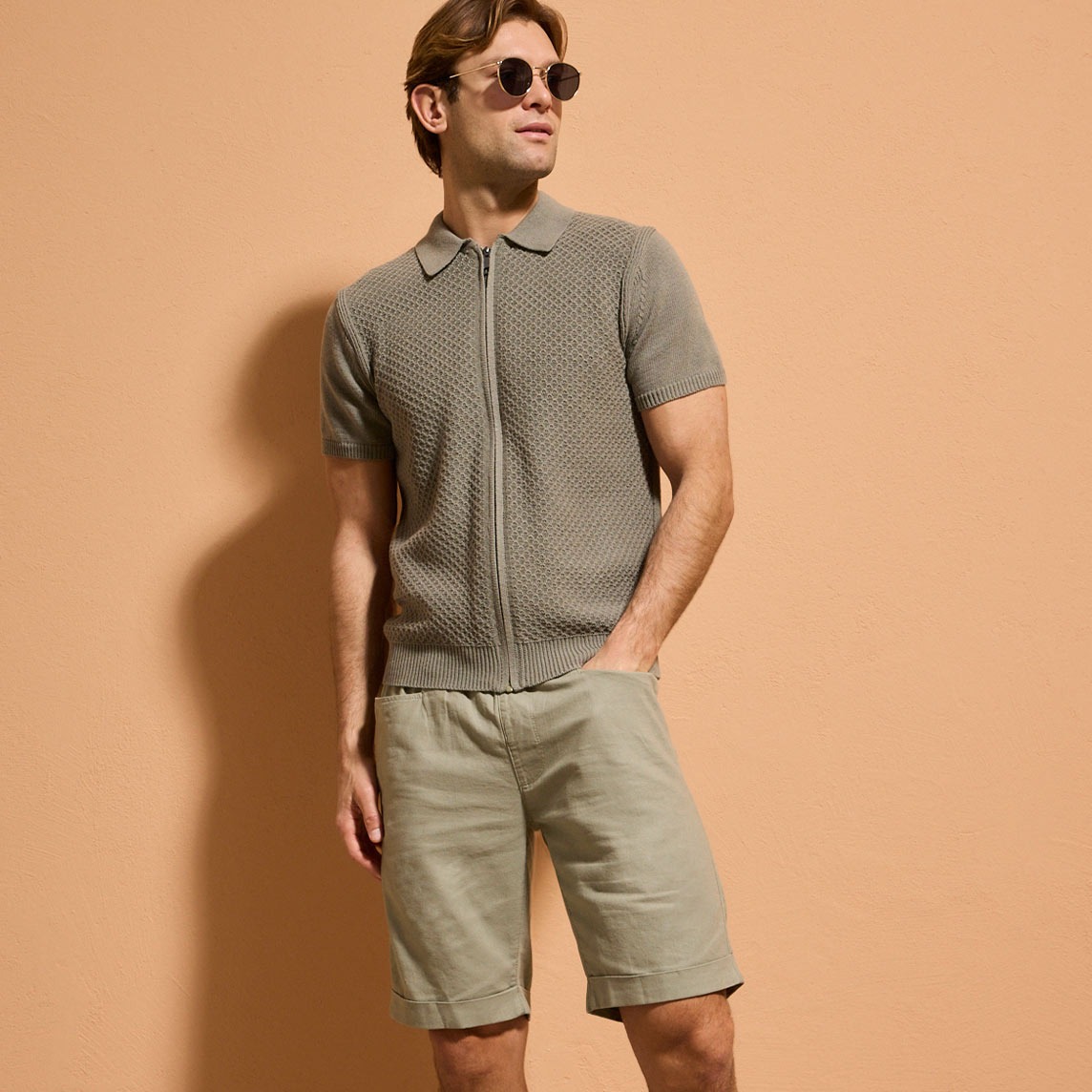 Olivefarbenes Poloshirt und beige Chino-Shorts für einen lässigen Sommerlook.