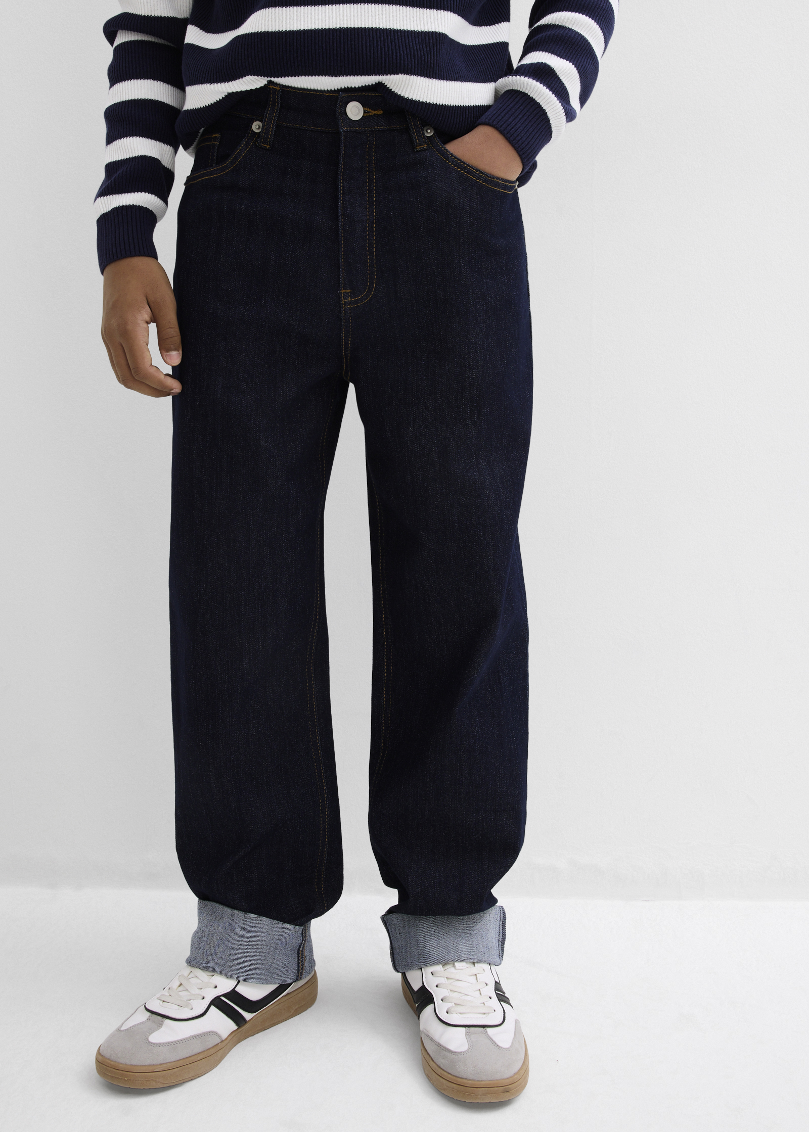 Weite dunkelblaue Jeans kombiniert mit gestreiftem Pullover.