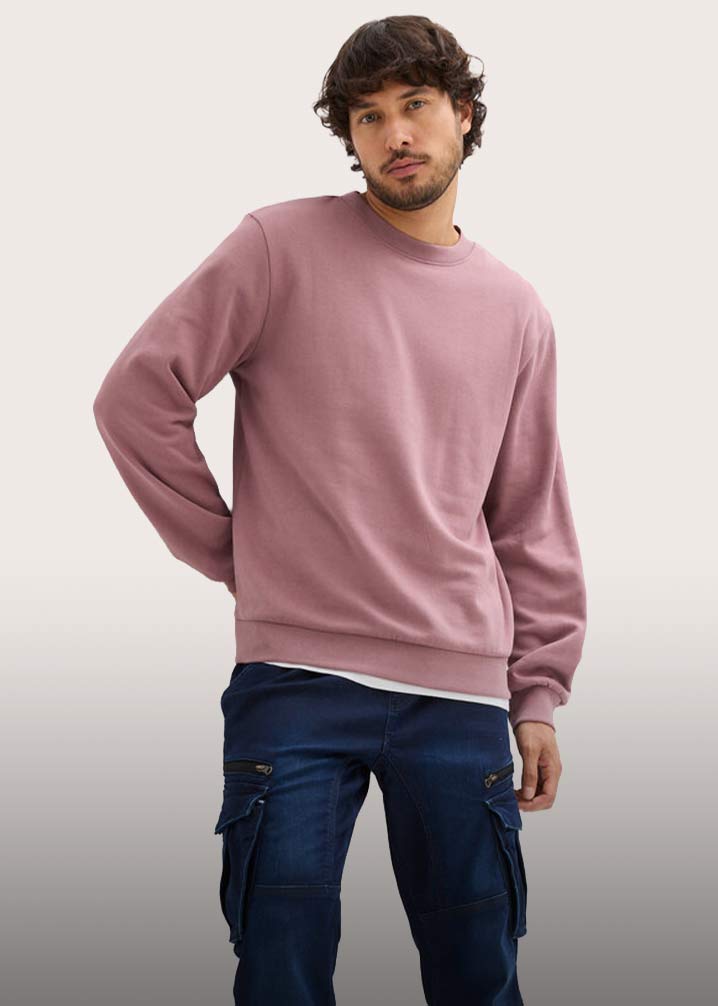 Altrosa Sweatshirt und dunkle Jeans. 